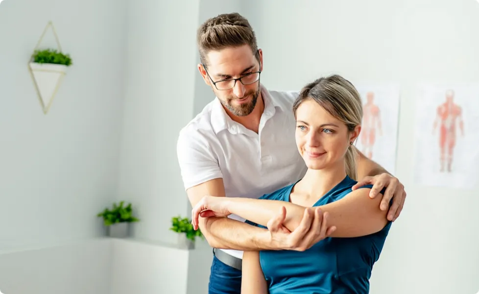 A physical therapist helping a patient perform an arm stretch.